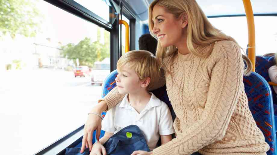 Young boy and mother go to school on the bus together.